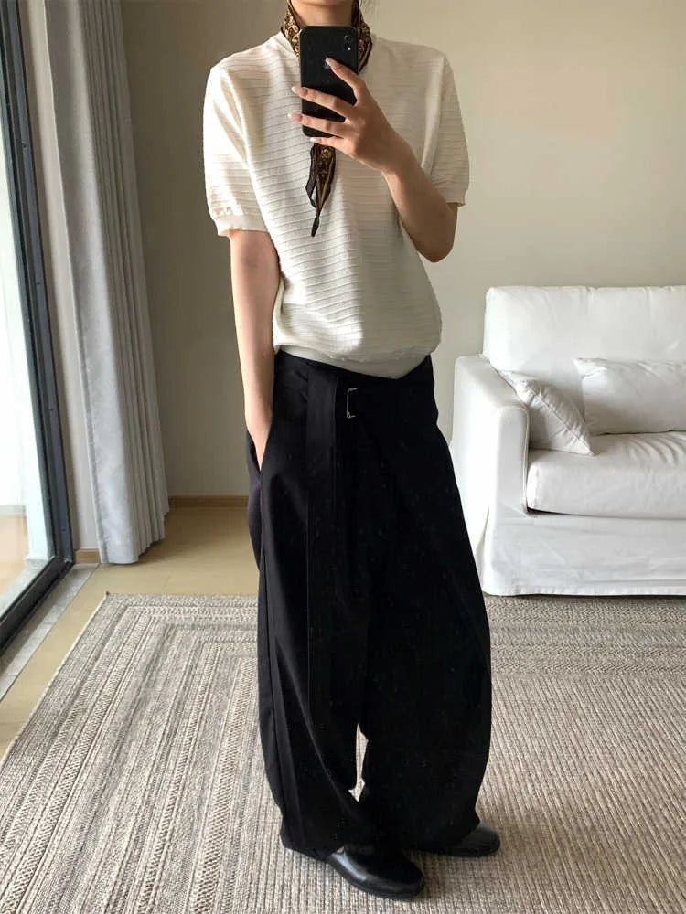 Black straight-leg trousers with adjustable waist and single pleat detail on a hanger.