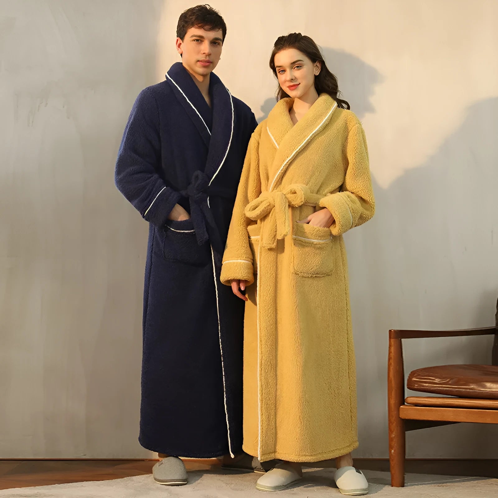 Man and woman wearing matching thick navy blue flannel bathrobes, showcasing the extended length and winter fabric.