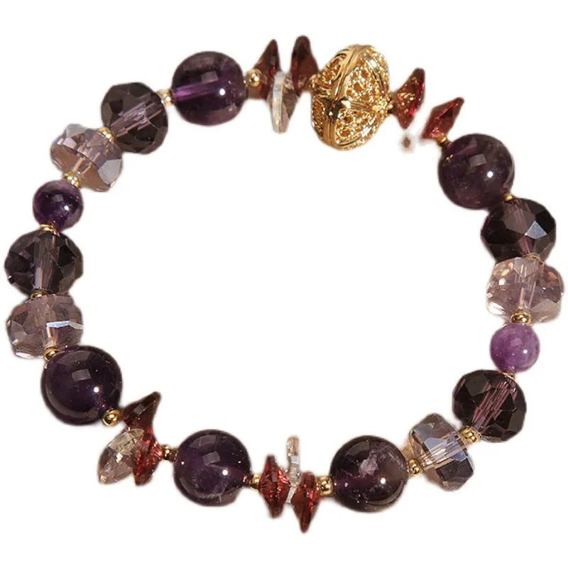 Purple crystal bracelet with pumpkin-shaped beads and rhinestone accents on a wrist.