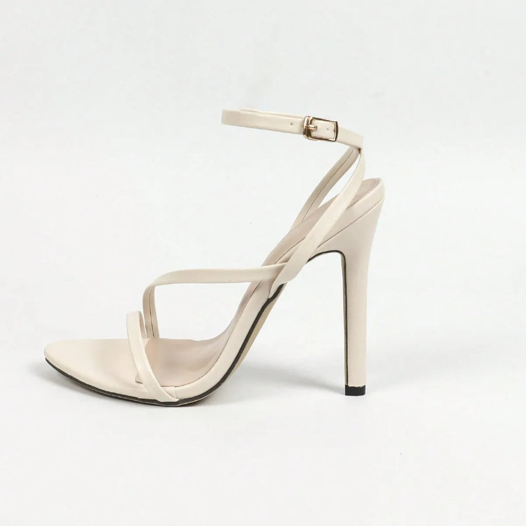 Women's gold high heel sandals with an open toe and cross ankle strap on a plain background.