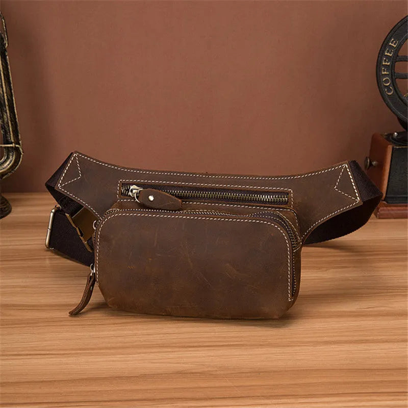 Brown top layer cowhide men's waist bag with pull cord closure, shown with a 10-inch laptop and mobile phone.