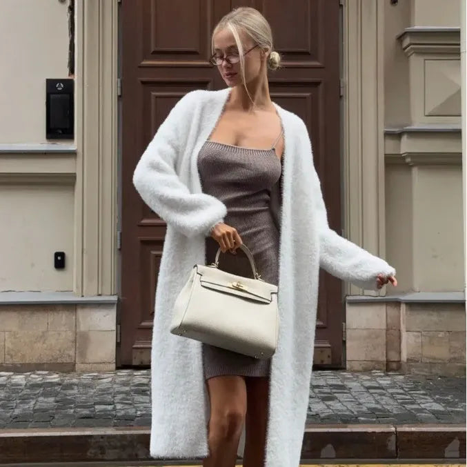 White long sleeve knitted cardigan jacket with a loose fit and extended length.