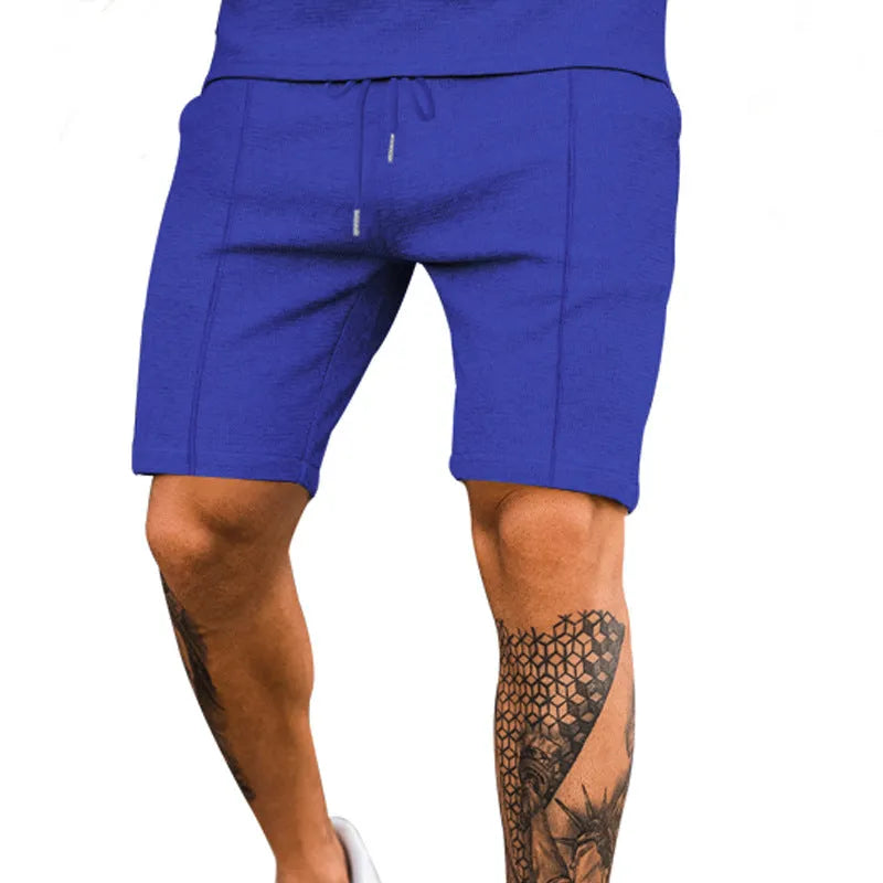 Solid colour five-point polyester sports shorts in khaki with elastic waistband, side view on model