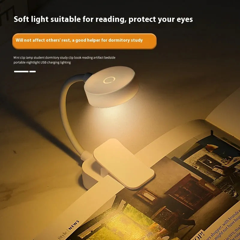 White plastic rechargeable LED book clip light clipped onto a book with USB charging cable