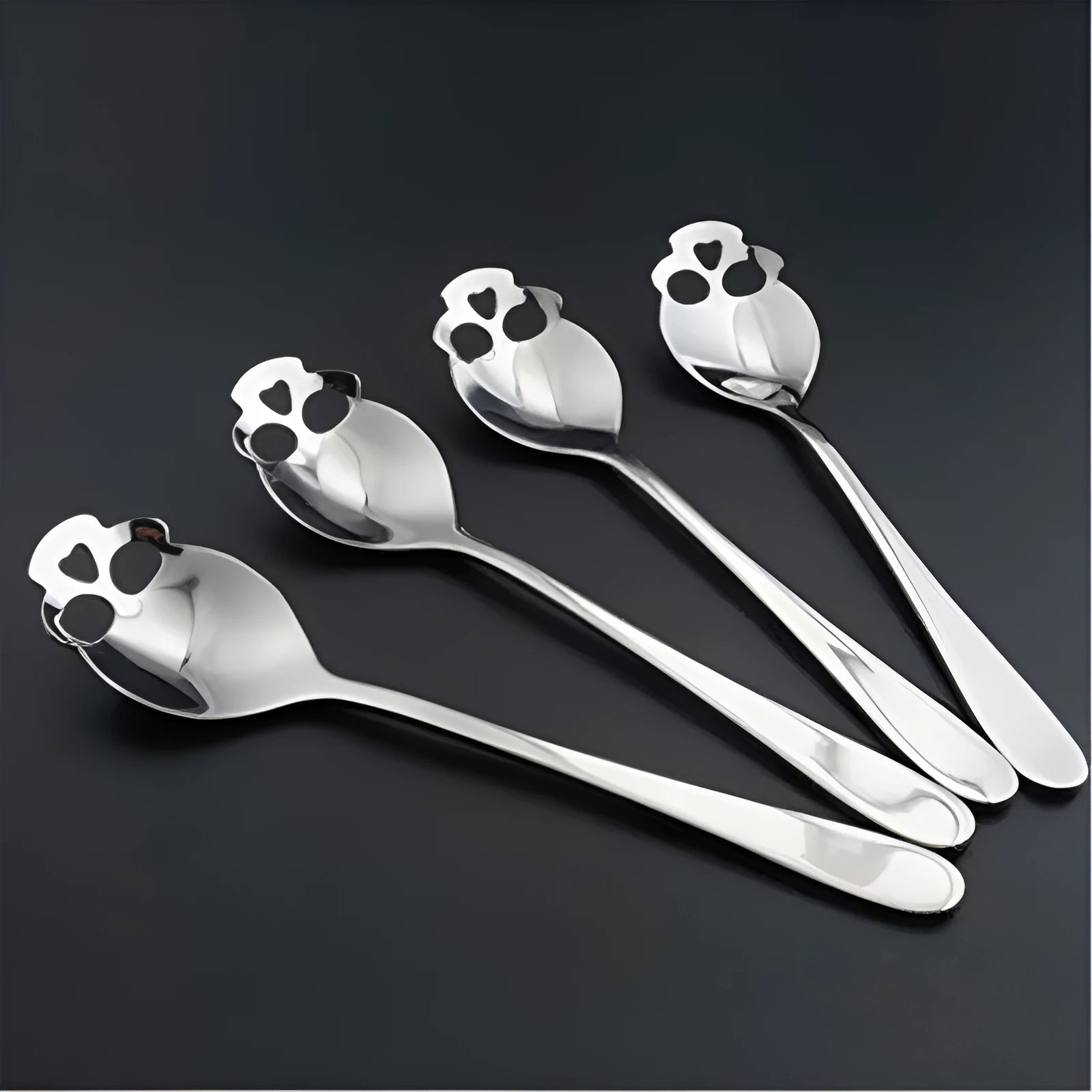 Stainless steel skull-shaped coffee spoon with polished finish on a flat surface