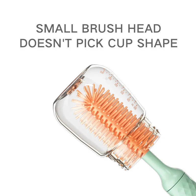 Pink and green electric rotating bottle cleaning brush with silicone bristles on a white background.