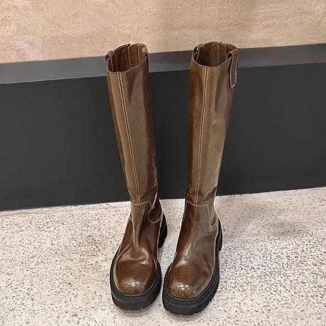 Women's black knee-high round toe boots with a chunky heel and back zipper on a white background.