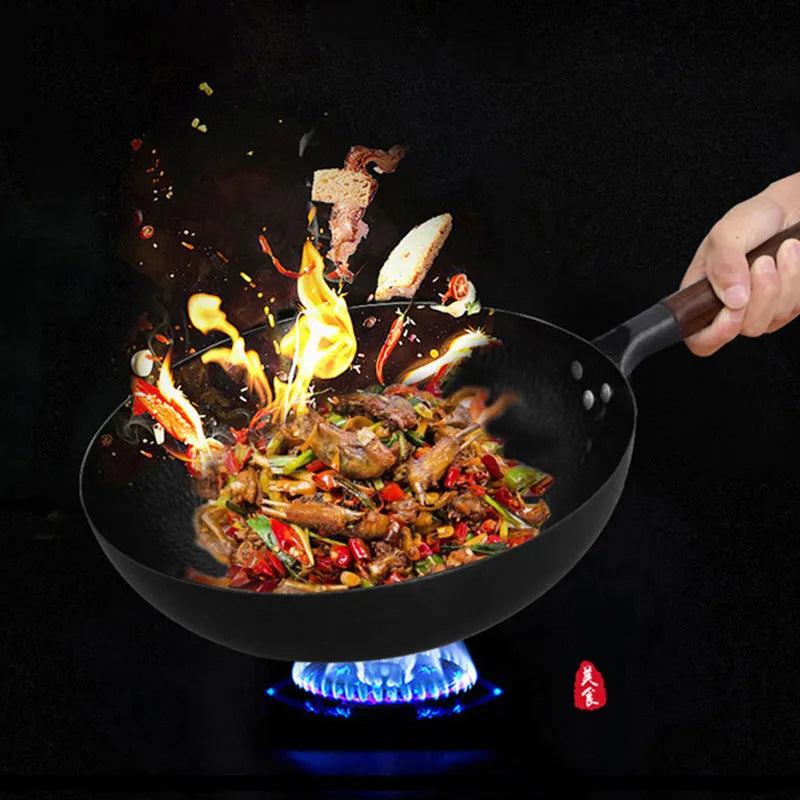 Black handmade iron wok with wooden handle, 32cm diameter.