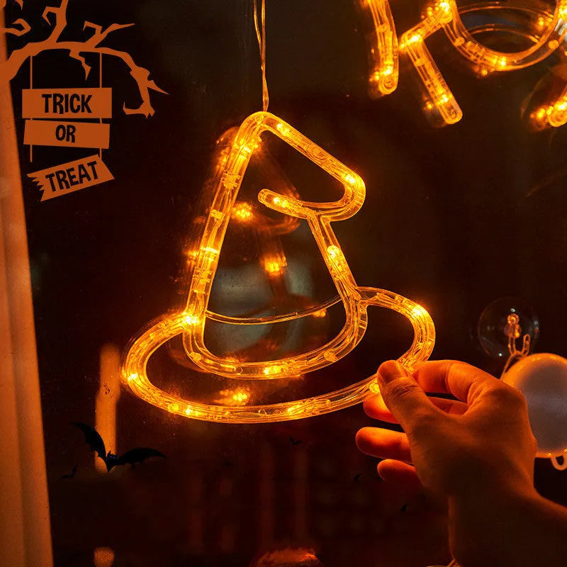 Halloween battery-powered LED window lights with spider, pumpkin and ghost figures hung by suction cups.