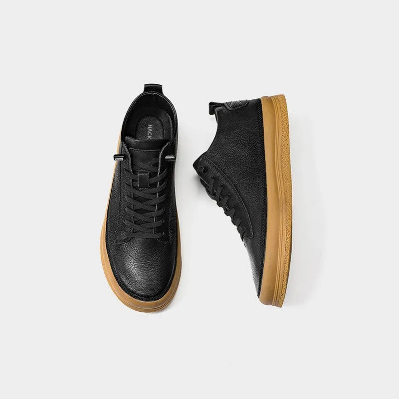 Men's black casual leather shoes with round toe and white rubber sole on a plain background.