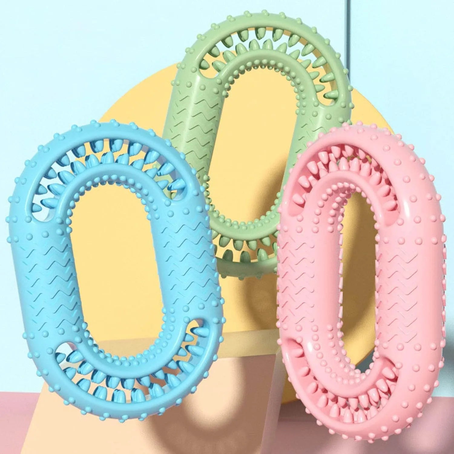Blue, green, and pink O-ring shaped heavy chew resistant dog toy for aggressive chewers.