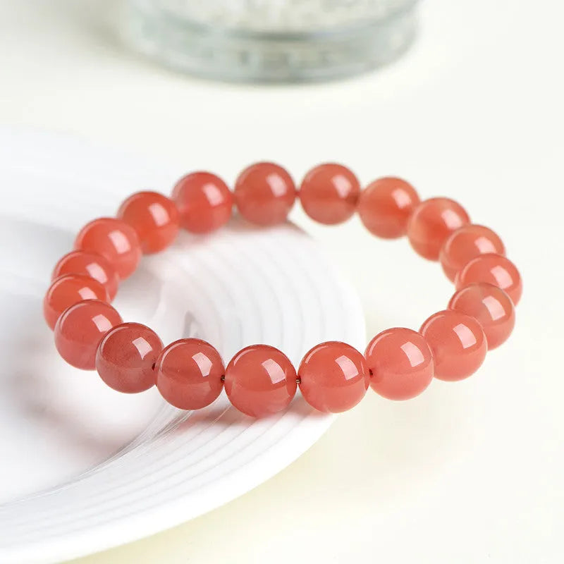 Natural cherry red agate beaded bracelet showing polished stones on a wrist, demonstrating single and triple strand options.