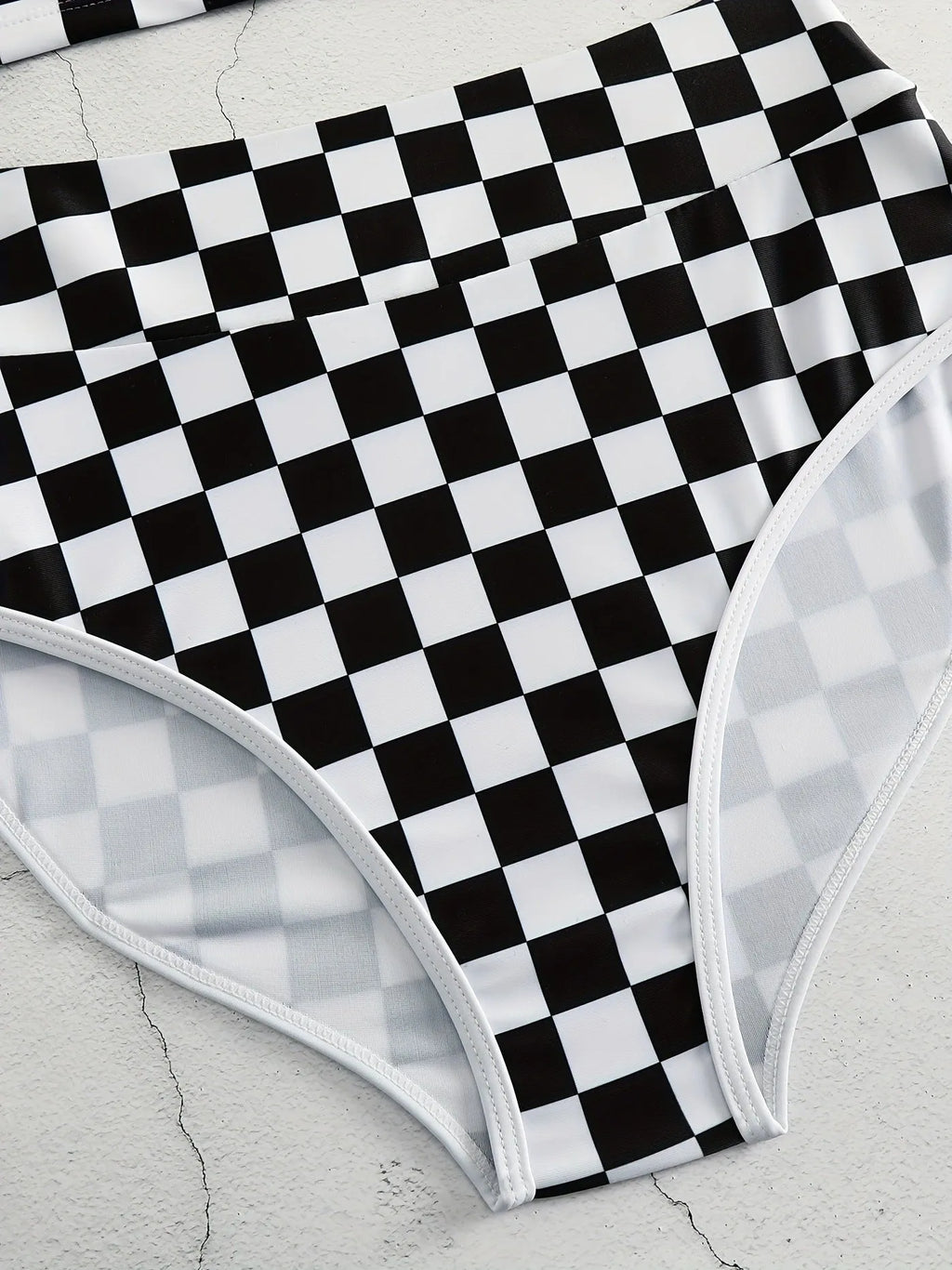 Adult female backless racing swimsuit with suspender straps in checkerboard print pattern