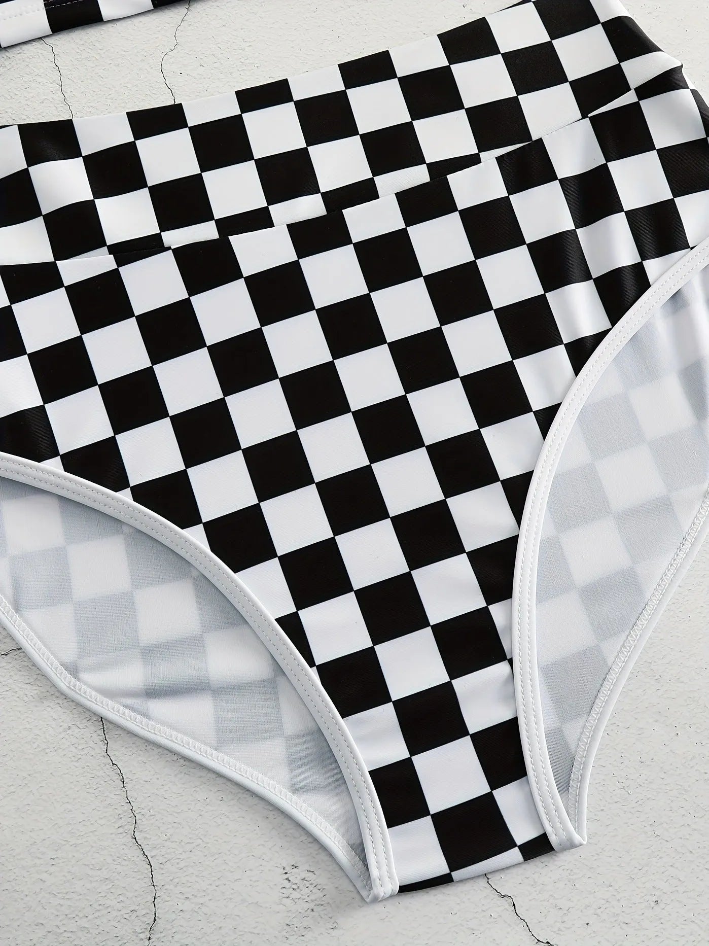 Adult female backless racing swimsuit with suspender straps in checkerboard print pattern