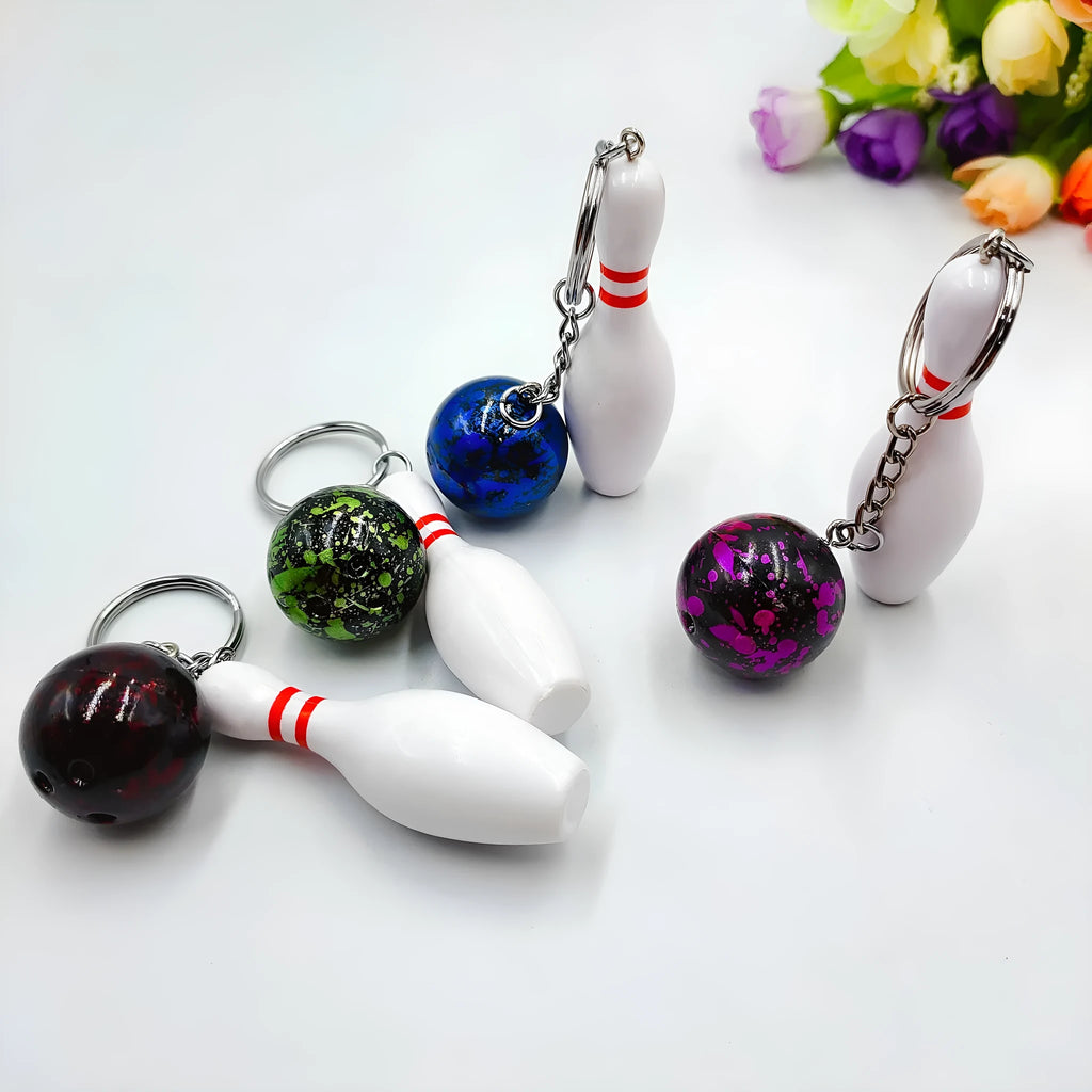 Mini bowling pin simulation keychain in blue, red, green, and purple colours on a metal ring.