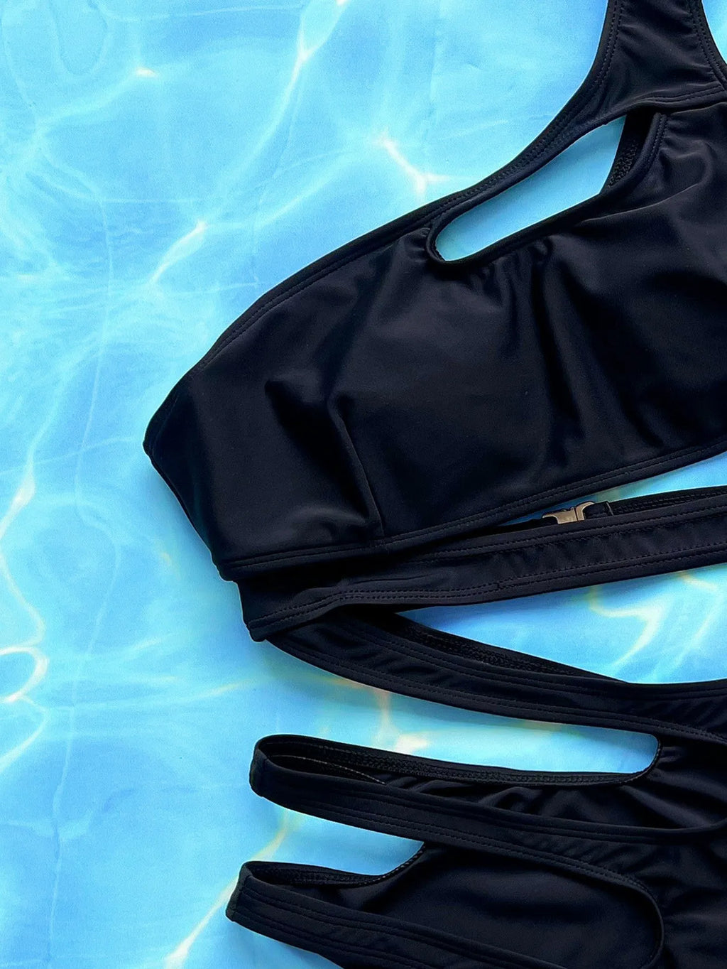 Black women's one-piece swimsuit with hollow out strap design on mannequin.