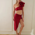 Women's black two-piece swimsuit with a large 3D flower design on the front.