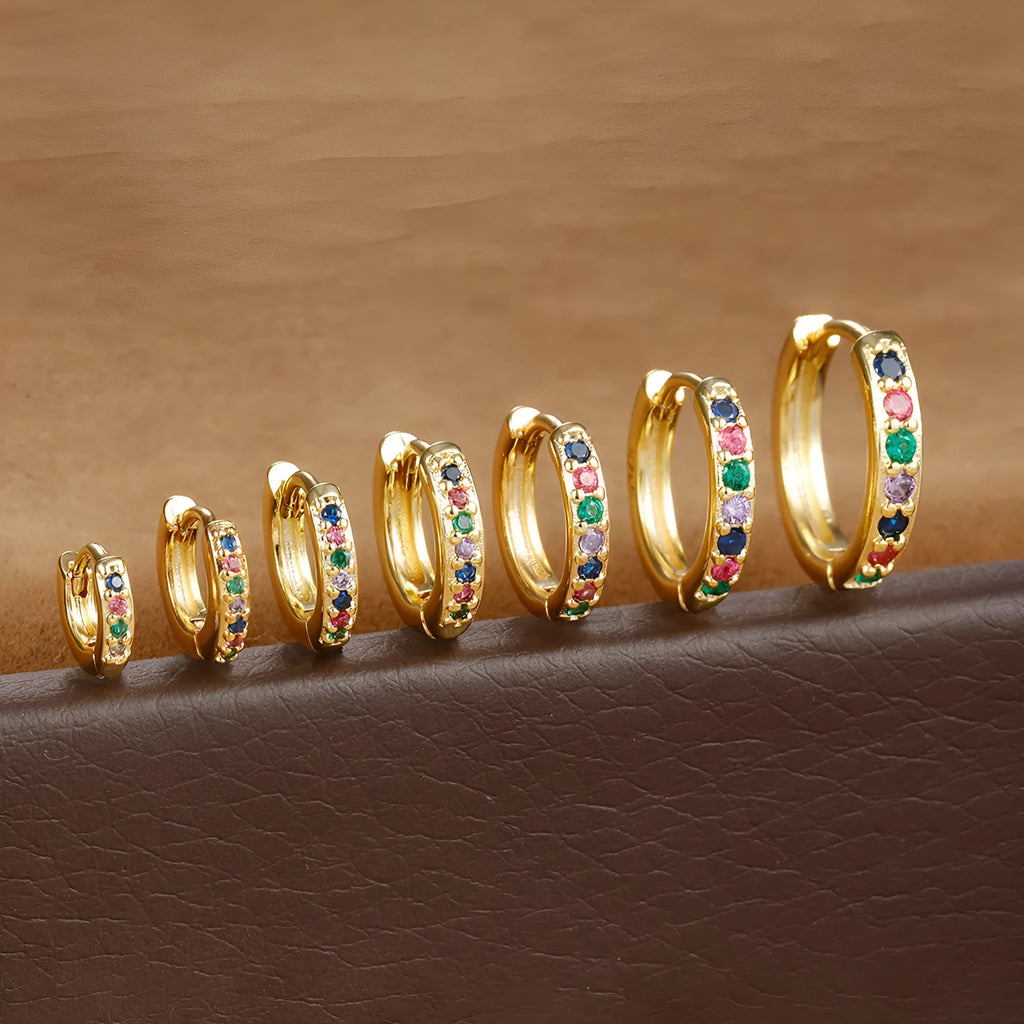 Circle-shaped cubic zirconia stud earrings in gold, rose gold, and silver colours on a white background.