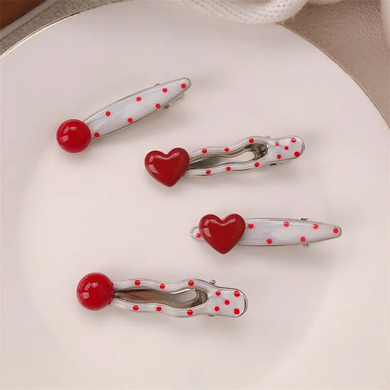 Red handmade hair clip shaped like a 3D love heart with vintage white dots, on a white background.
