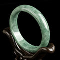 Natural emerald bean green women's bracelet on a gift box, showing simple design and deep pea green stone colour.