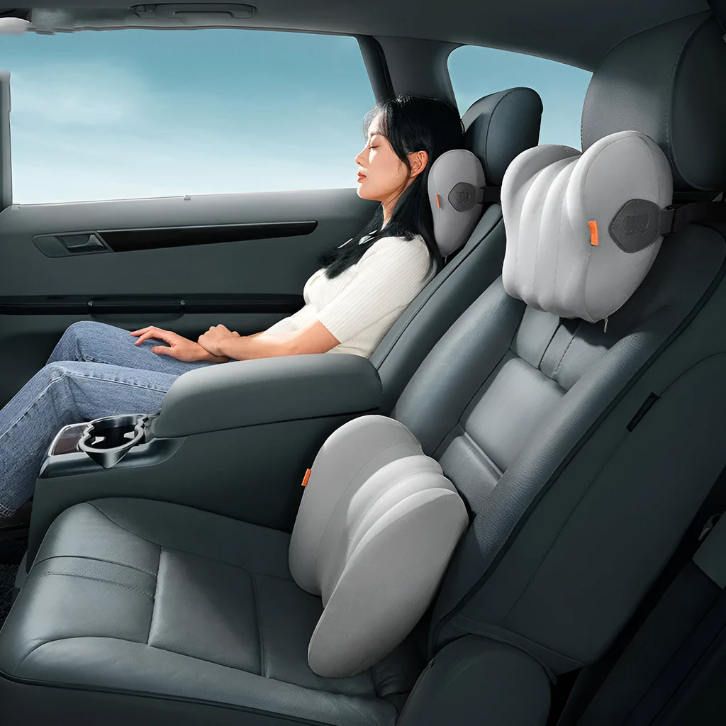 Grey and orange car head restraint and lumbar pillow set on a car seat.