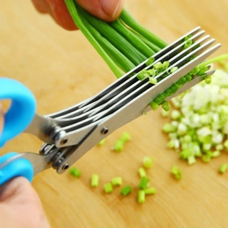 Stainless steel multi-layer kitchen scissors for cutting green onions and herbs on a chopping board.