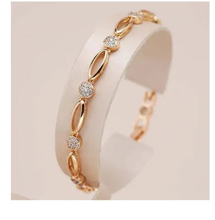 Golden hollow carved copper bracelet with U-shaped design on a wrist.