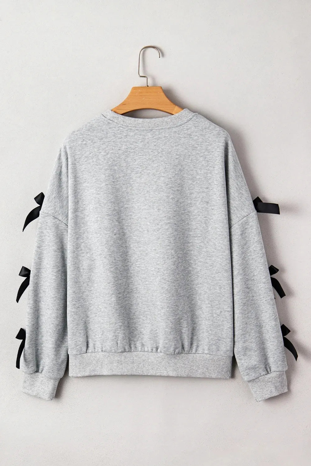 Women's light gray long sleeve ribbon slit letter shirt pullover front view on model