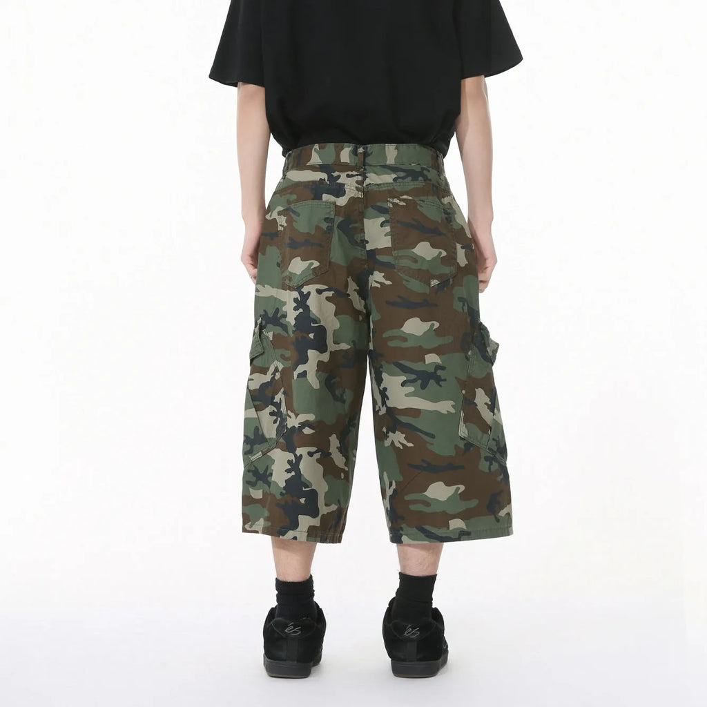 Men's cotton camouflage wide-leg cargo trousers with cropped length on a neutral background.