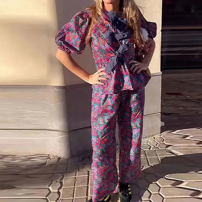 Women's floral print polyester trousers suit with puff sleeve top and matching trousers.