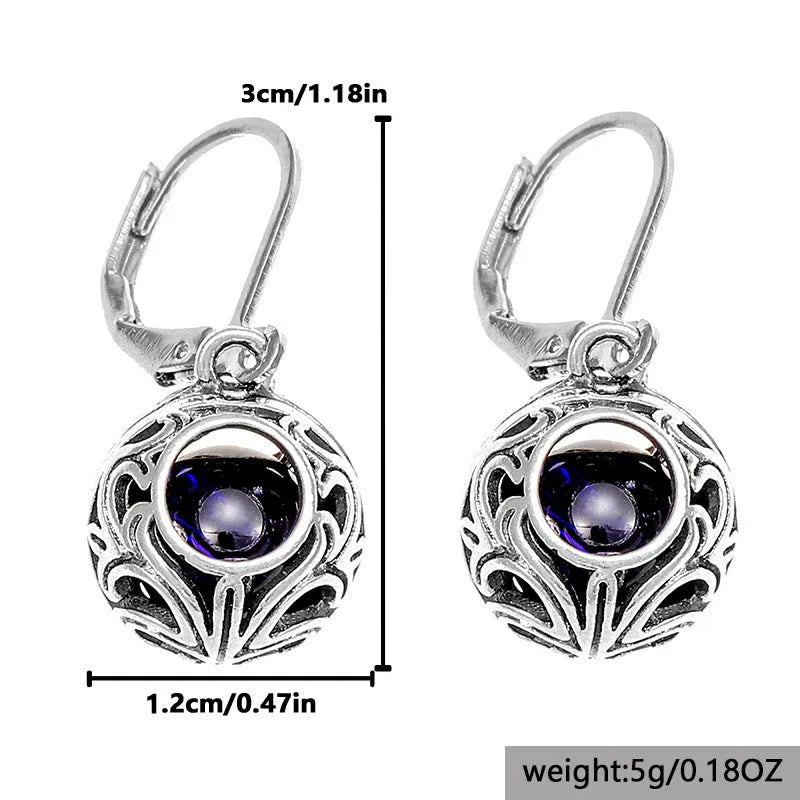 Silver tone geometric earrings with hollow pendant designs and blue gemstone accents