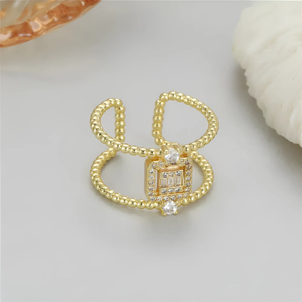 Gold-coloured asymmetric U-shaped open ring with an adjustable gap on a plain background.