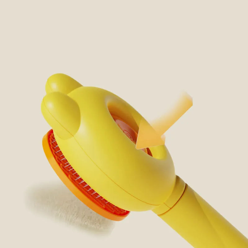 Self-cleaning cat brush with release button showing stainless steel teeth with rubber tips