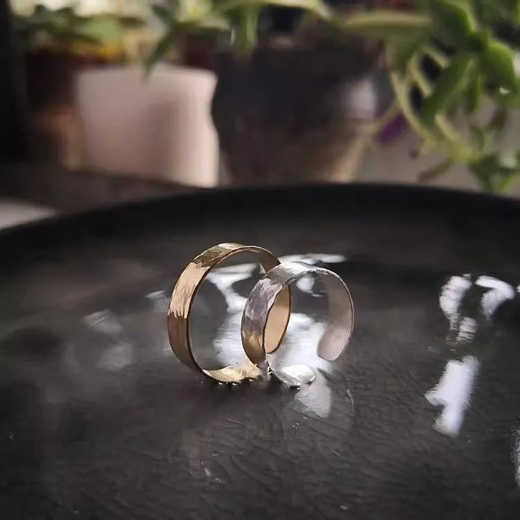 Golden hand-hammered alloy toe ring with open design on a woman's foot