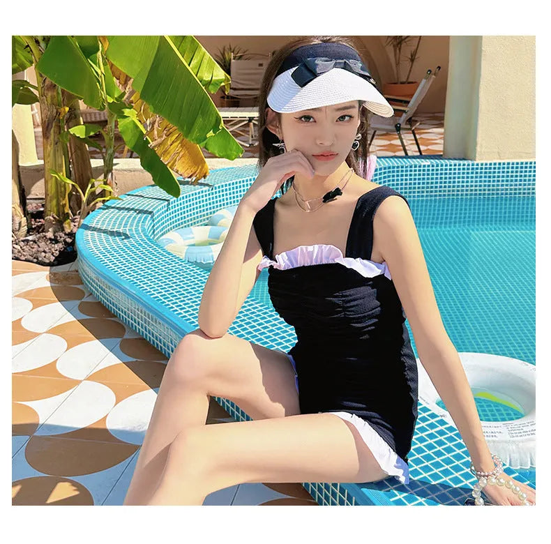 Women's solid colour one-piece swimsuit with suspender straps in pink, green, or black options