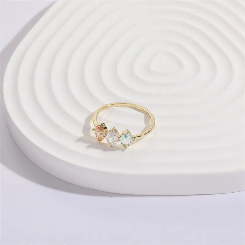 Geometric copper ring with a triangular tricolour zircon birthstone in a horse eye design, showing 14k gold electroplated finish.