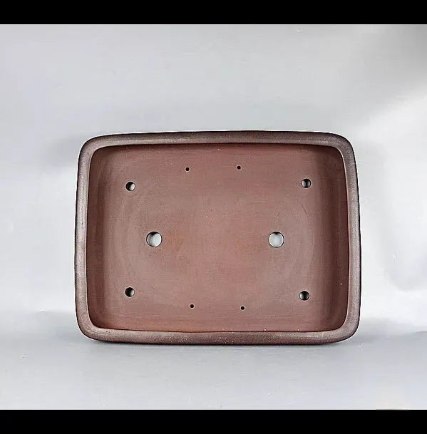 Handmade large rectangular purple clay flower pot for floor plants on a table.
