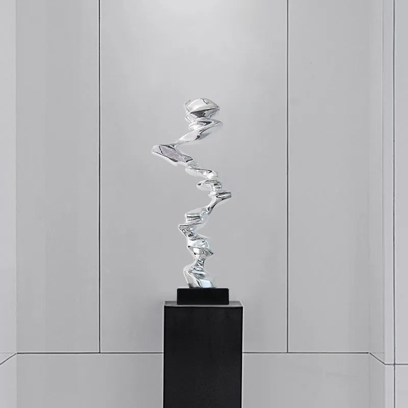 Ran Ran Rose abstract resin sculpture in bright gold, silver, or blue on a neutral background.