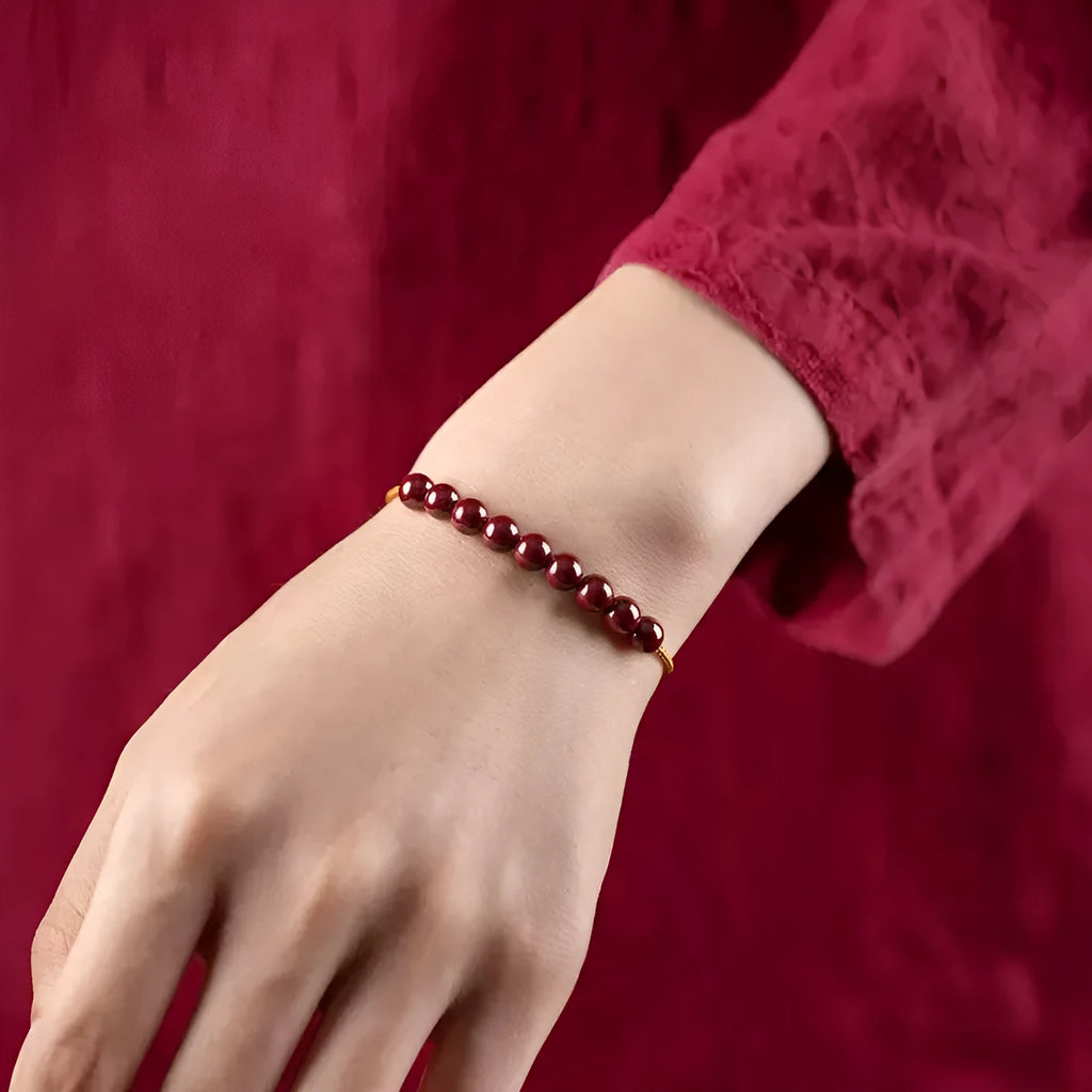 Hand-woven cinnabar bracelet with geometric design showing natural mineral colours