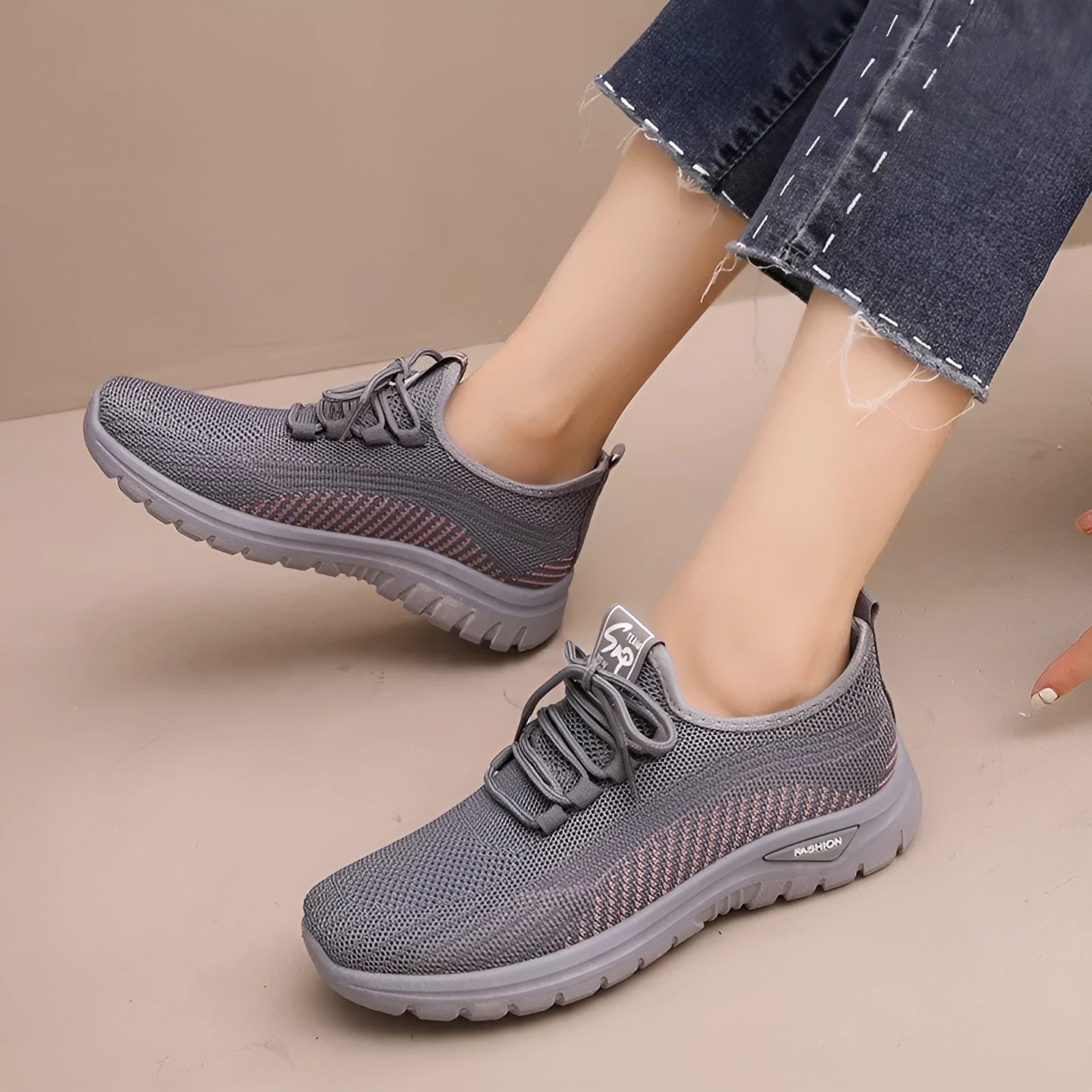Women's black mesh sneakers with cross strap detail and round toe on a rubber sole.