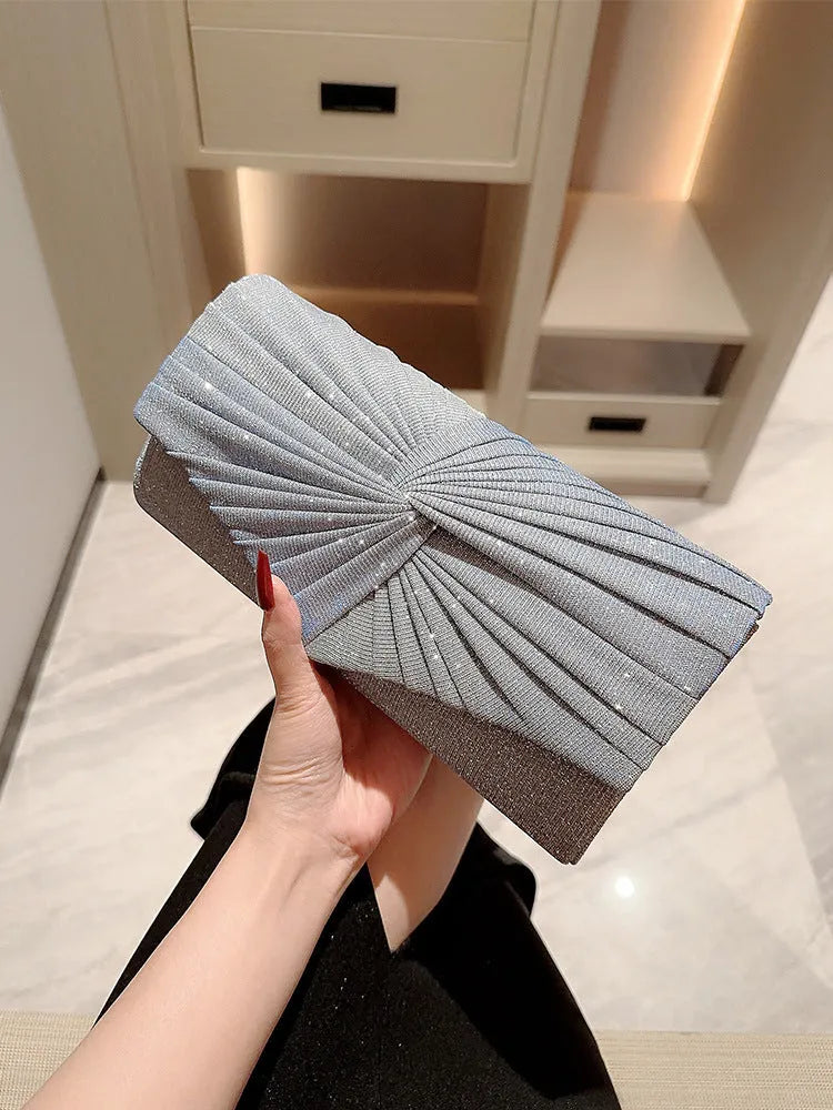 Horizontal square dinner clutch in silver or gold with woven exterior, open pocket, and internal phone bag.