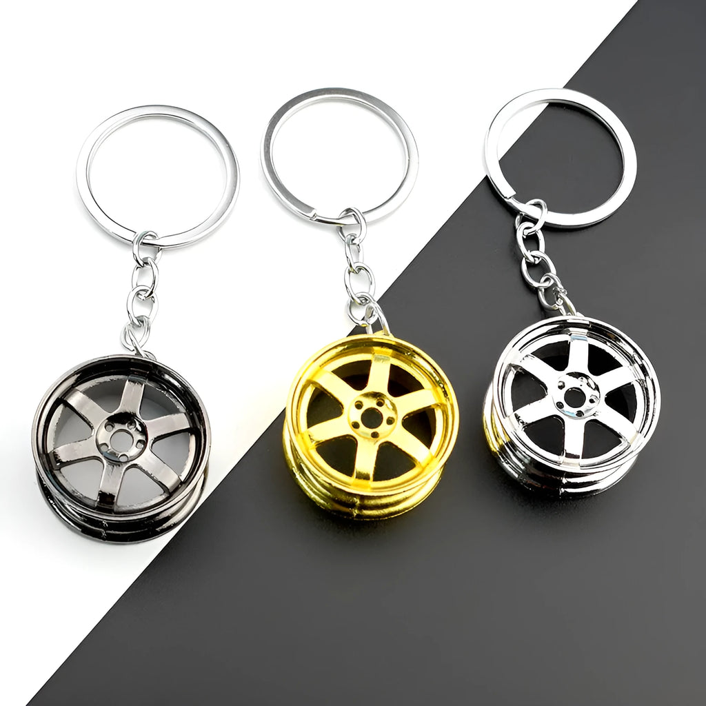 Zinc alloy car wheel hub keychain in gold, silver, and black colour options.