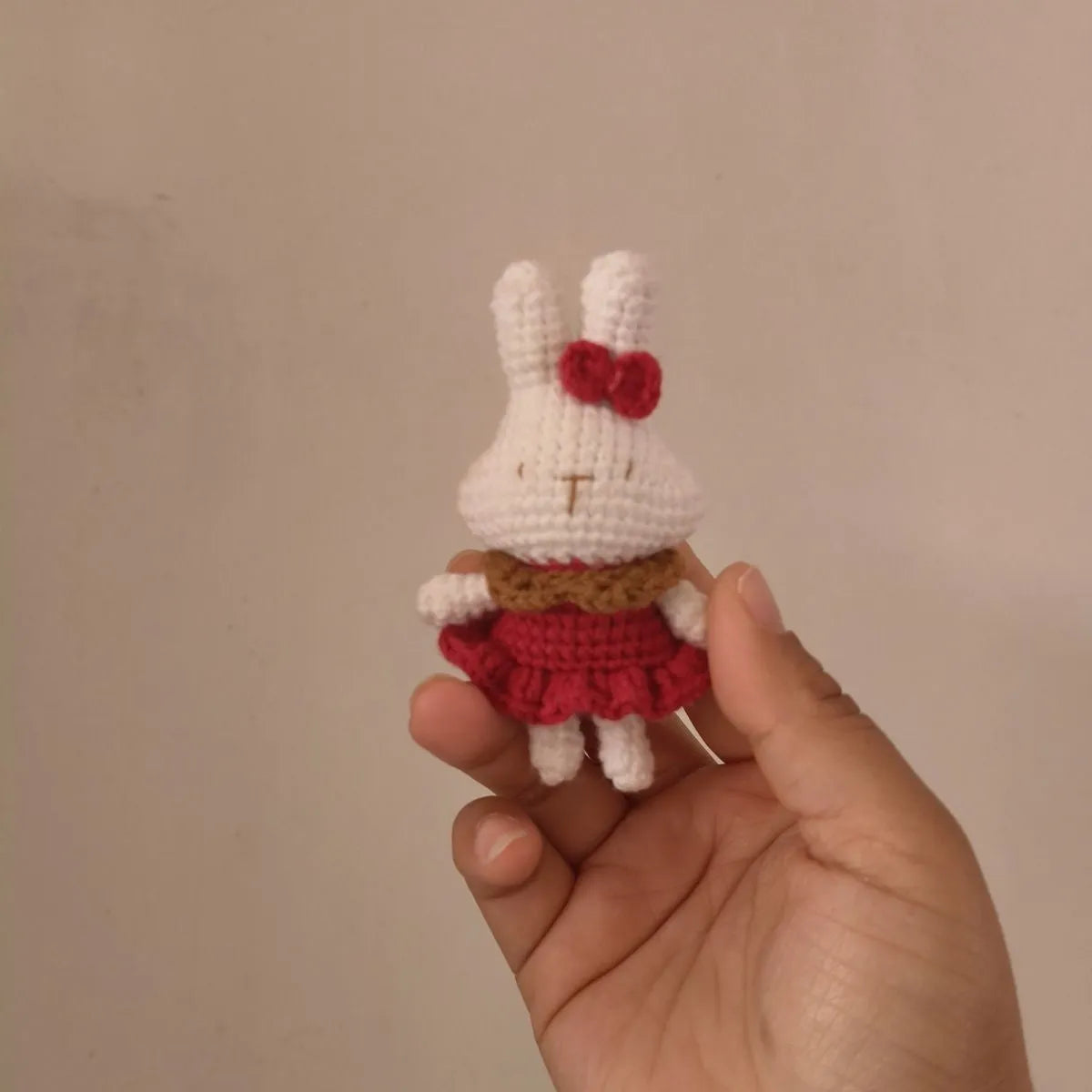Hand-crocheted wool rabbit key chain with cute design, shown in two style options