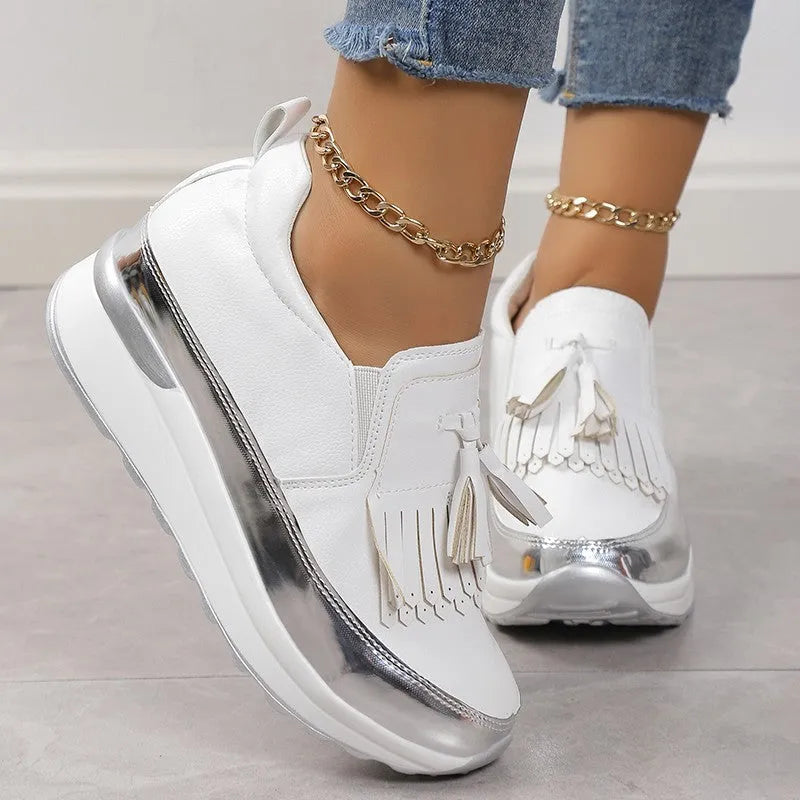Women's black casual platform shoes with tassel decoration and a distinctive English muffin wedge heel.
