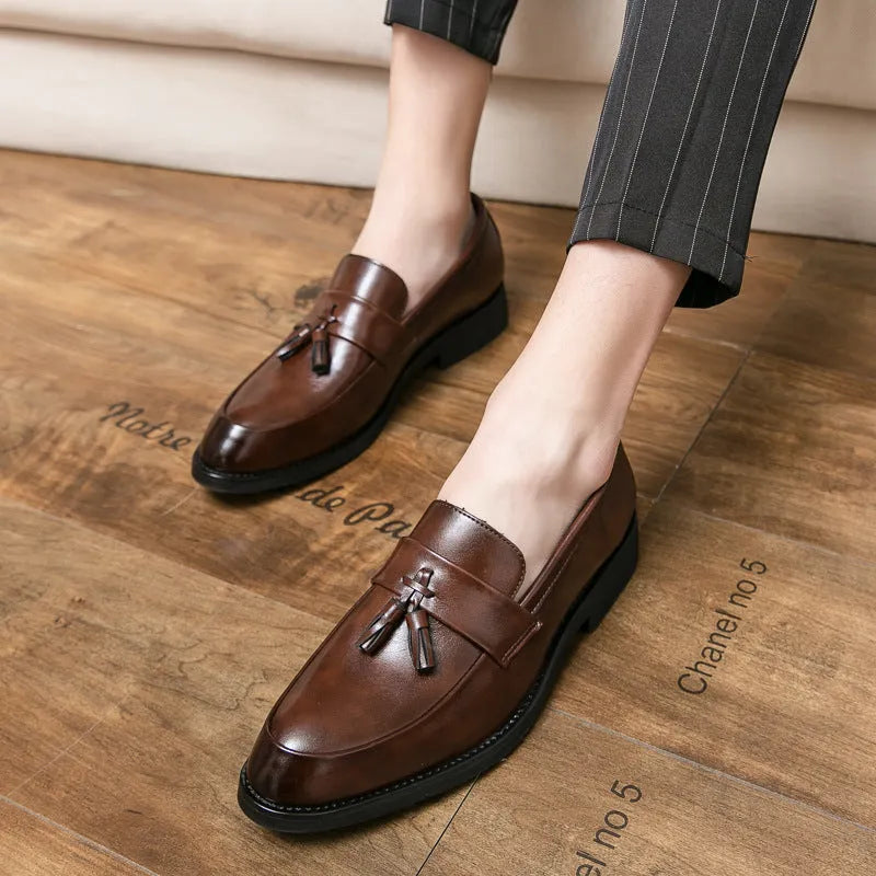 Men's black slip-on loafers with a tassel decoration on a pointed-toe, low-top artificial PU upper.