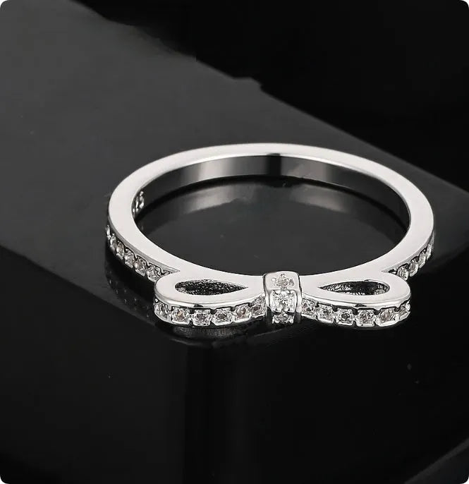 Silver plated fashion ring featuring a detailed 3D bow design set with sparkling zircon crystals on a plain band.