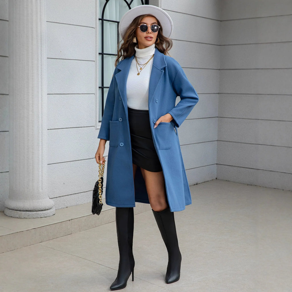 Blue waist-tie mid-length women's wool coat with long sleeves, pockets, and patchwork details