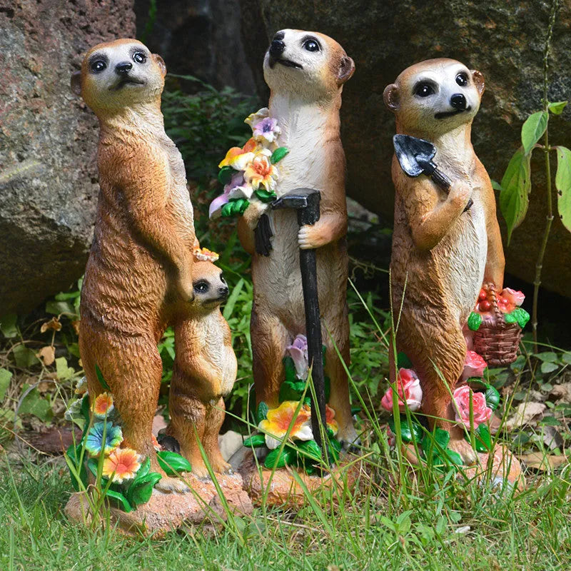 Three straw hat mongoose garden ornaments including mother and child grouping plus figures with rake and shovel