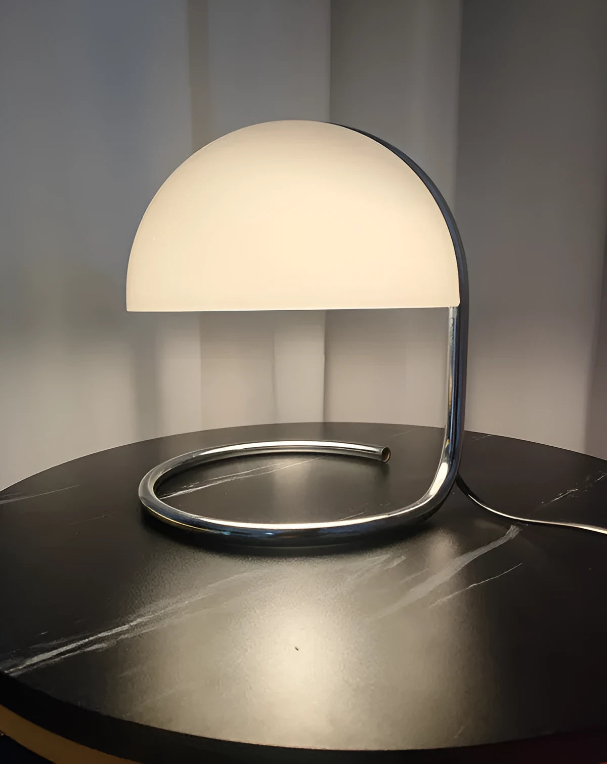 Retro metal mushroom table lamp with three-colour light in orange finish on a bedside table