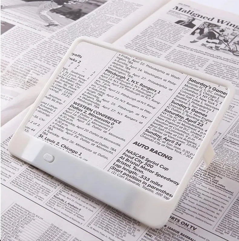 Black and white LED magnifying glass with 3x lens on a desk